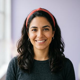 Retrato generado de una desarrolladora sonriendo, imagen de muestra